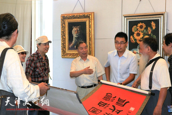 天津知名油画家新作品在中惠团泊湾展出，图为何德谦为画展献上书法作品。