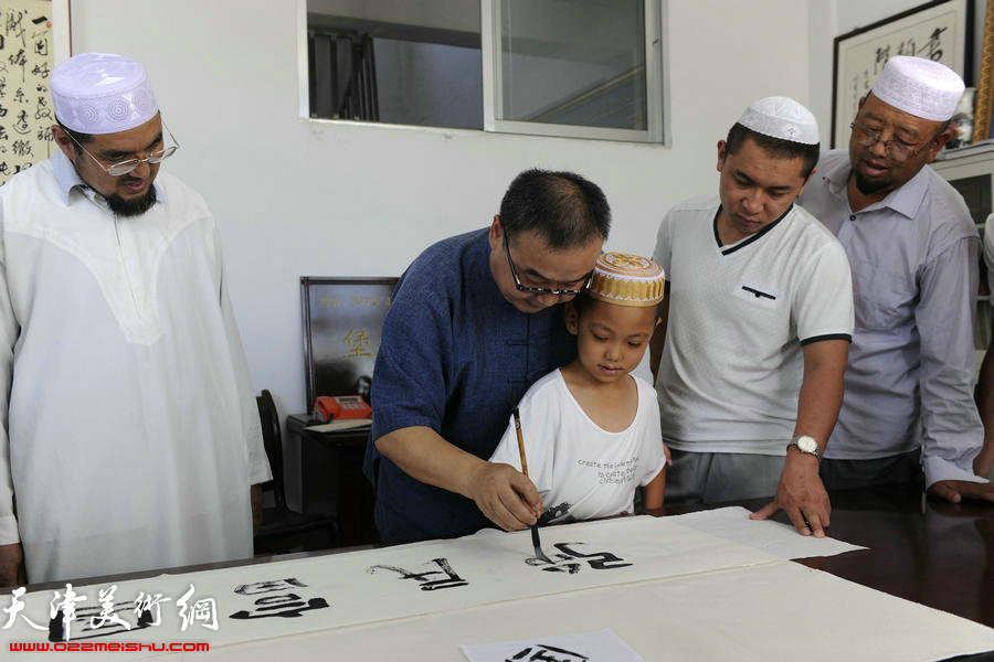 封俊虎先生辅导回族小朋友志芸书法（2014年）。