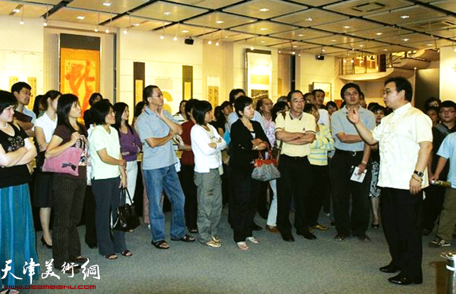 封俊虎先生在马来西亚举办个人书法展，图为向观众现场讲解。（2008年）