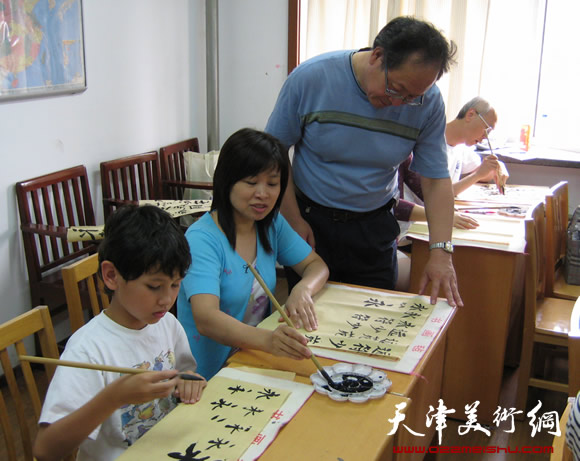 姜钧杰正在指导学生学习书法