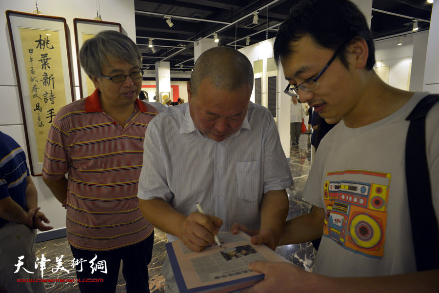 别有黛色—张福义、康国林、马孟杰三人书法展亮相天津日报美术馆。图为马孟杰在现场为观众签名。