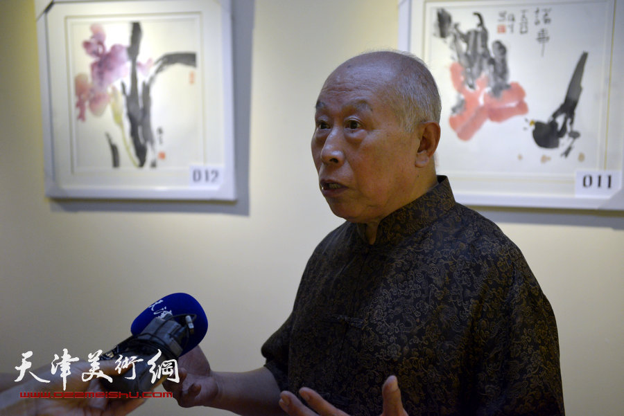 王俊生在画展现场接受媒体采访。