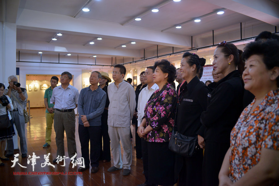 图为市区领导与来宾观看梁崎先生精品书画展。