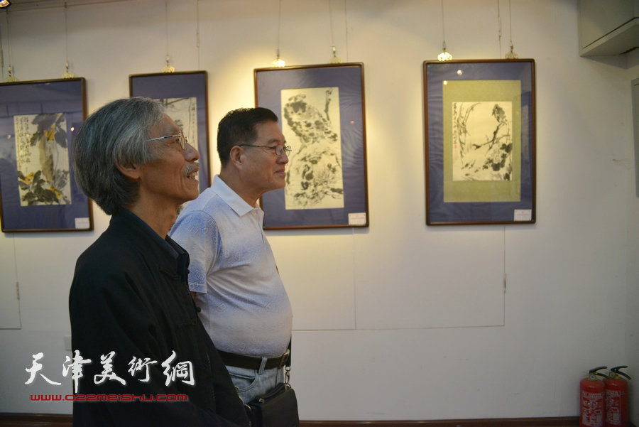 图为姚景卿观看梁崎先生精品书画展。