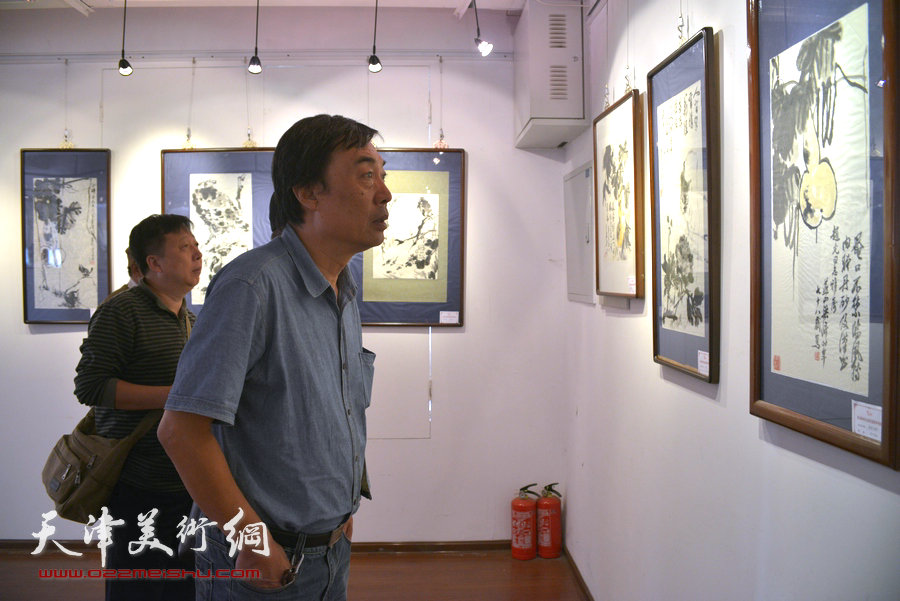 图为杜晓光观看梁崎先生精品书画展。