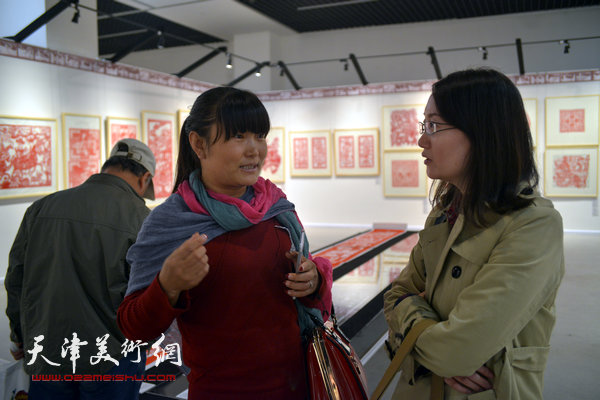 2014“西岸”剪纸艺术展现场。图为北方网记者吴宏采访参展作者。