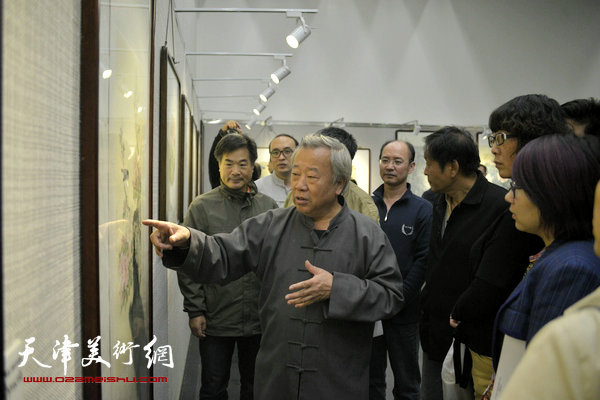 图为阮克敏在画展现场为学生解画。