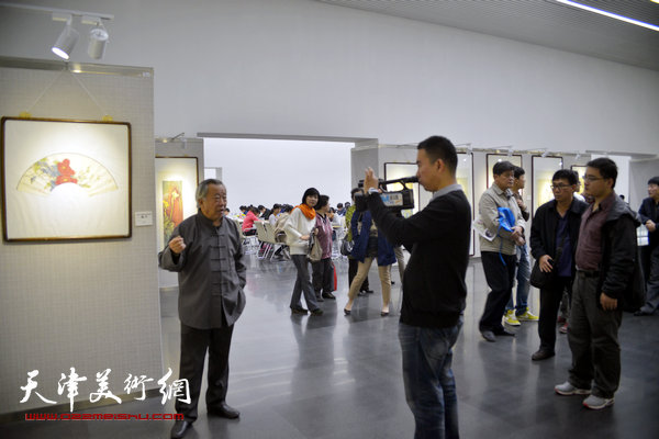 图为阮克敏在画展现场接受媒体采访。