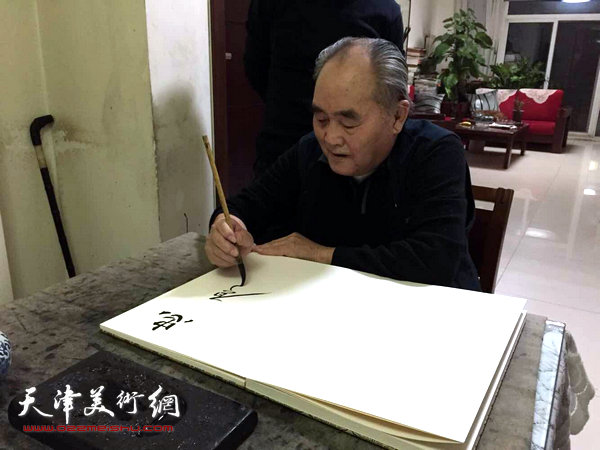 图为孙伯翔先生正在为画展题写贺词。