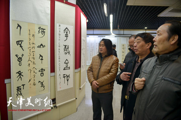 向中林、李祥平、孙富泉在书画展上观看展品