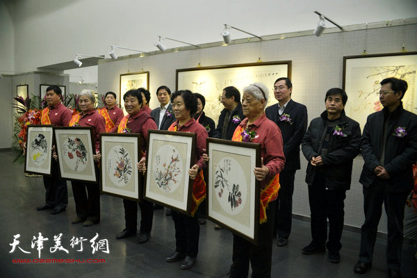 金涌焱向天津市劳模志愿者赠送新创作的《小五羊图》。