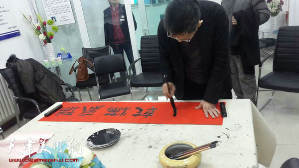 图为李毅峰现场为社区居民书写横幅。