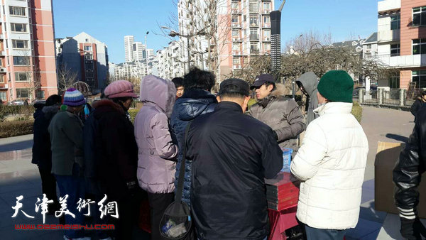 图为天津人民美术出版社在瑞江花园小区开展新春惠民活动。