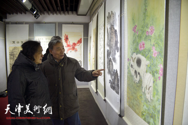 图为参展画家娄羚儒、崔梦茹等在书画展现场。