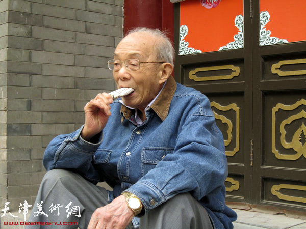 走热了，吃颗冰棍。2012年10月5日，101岁的夏明远游天津古文化街。