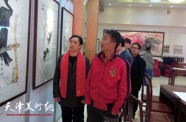 张大功陪同邓国源观看作品。