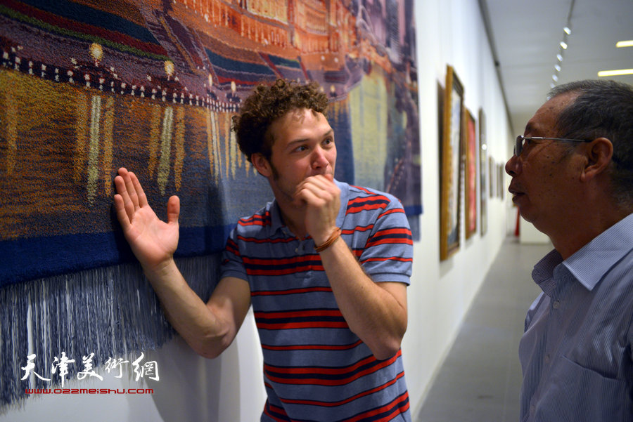 图为工艺美术大师李临潘向外国友人介绍作品。