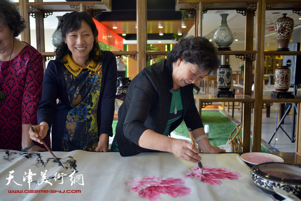 天津女子画院书画家募捐笔会现场，图为冯字锦、张荷芝。