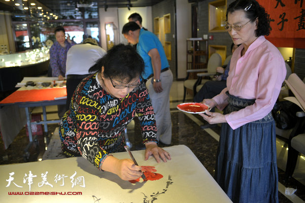 天津女子画院书画家募捐笔会现场，图为罗凌、张妤君。