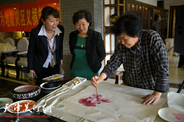 天津女子画院书画家募捐笔会现场，图为冯字锦、李淑芳。