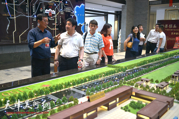 大城红木文化新城销售总经理胡颖向张鹤年、彭英科介绍红木新城的规划建设。