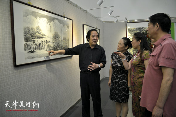 图为关山雨、张金荣等在观看作品