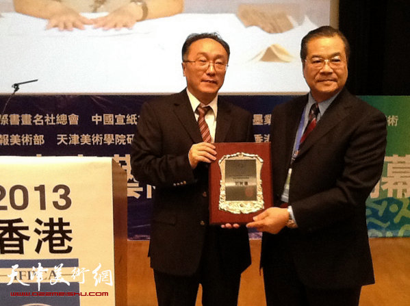 在香港书画论坛上，何东（左）为刘树德颁发“杰出书法导师奖”