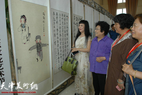 画家黄雅丽、李维娜陪同原宝坻区政协主席侯隽（左二）参观展览