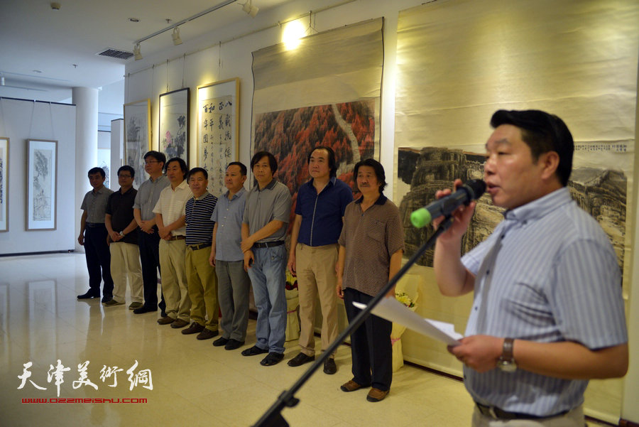 南开区政协委员、天津巨龙画院院长张维向观众介绍参展画家。