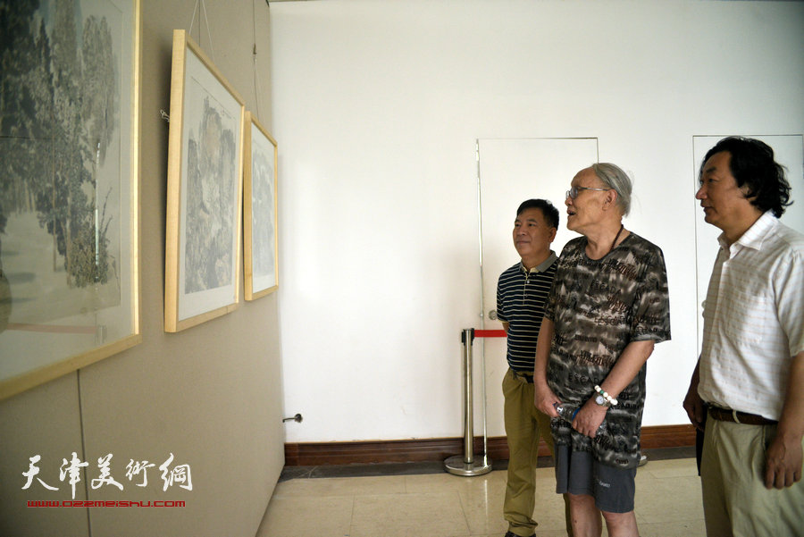 孙长康、韩石、金石在观看画作。
