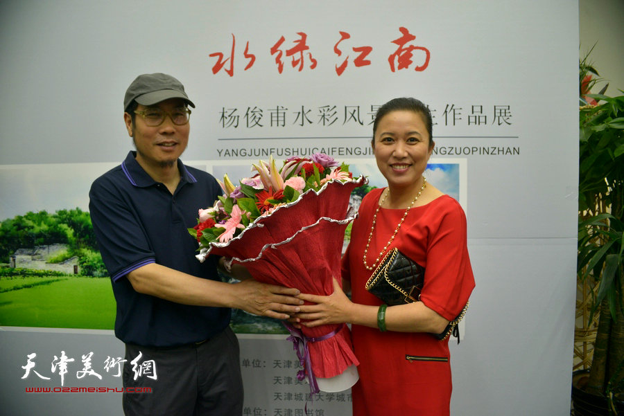 图为亲友为杨俊甫献花，祝贺画展成功。
