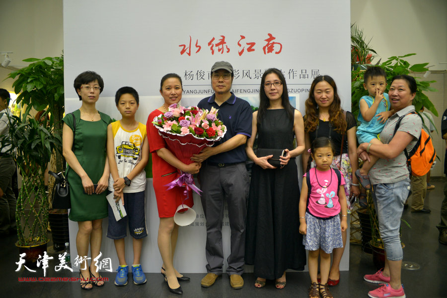图为亲友为杨俊甫献花，祝贺画展成功。
