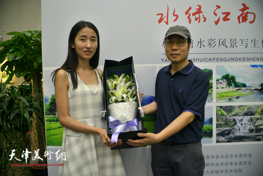 图为学生为杨俊甫献花，祝贺画展成功。