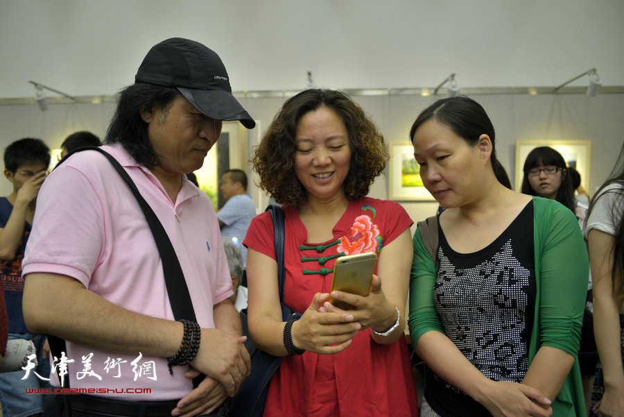 王刚、陶香莲在杨俊甫水彩风景写生画展上。