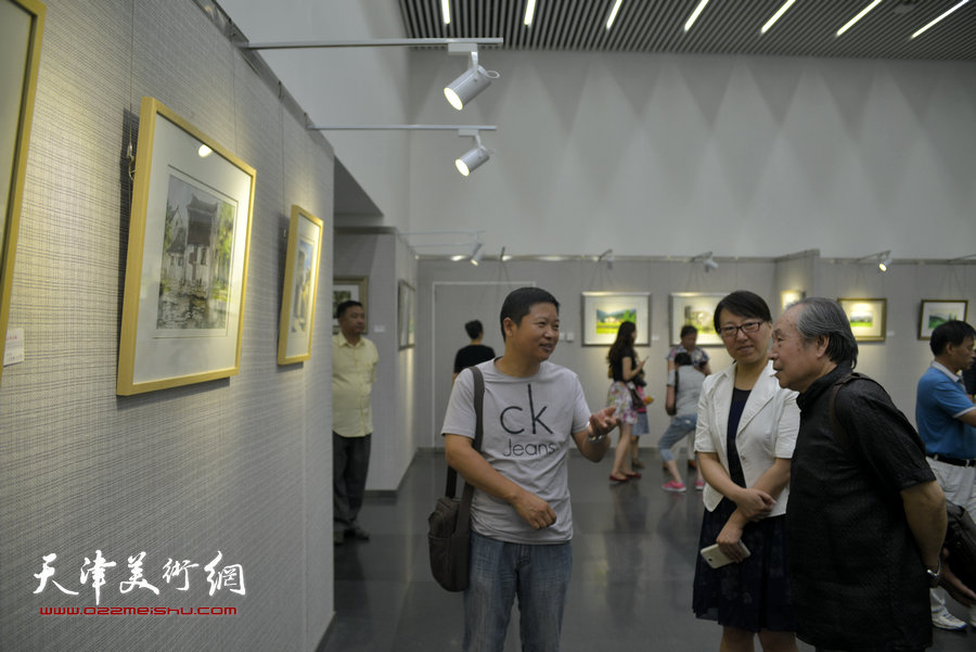 李宗儒、魏瑞江、方欣在观赏展出的作品。