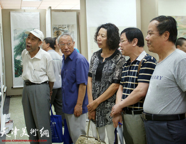 知名花鸟画家李根友（右二）为观众点评作品