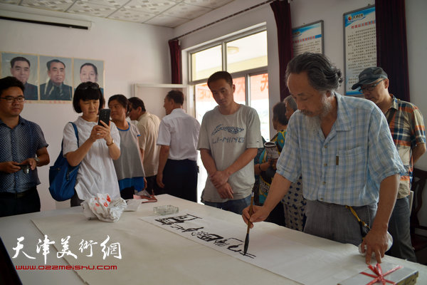 天津画院书画家为村民写横幅。图为刘栋。