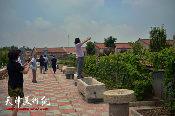天津画院书画家送文化进农家。图为贾广健将新农村美景收入镜头。
