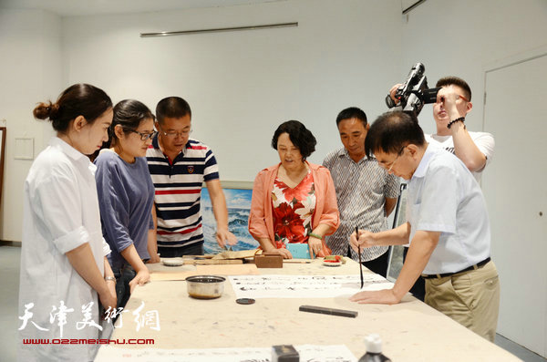 “相约齐鲁——王文元、关山雨国画•油画•书法烟台邀请展”暨“王文元、关山雨国画•油画•书法艺术研讨会”在烟台城市美术馆举行，图为王文元在画展现场进行书法创作。