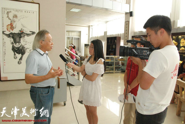 图为王金厚在展览现场接受媒体采访。