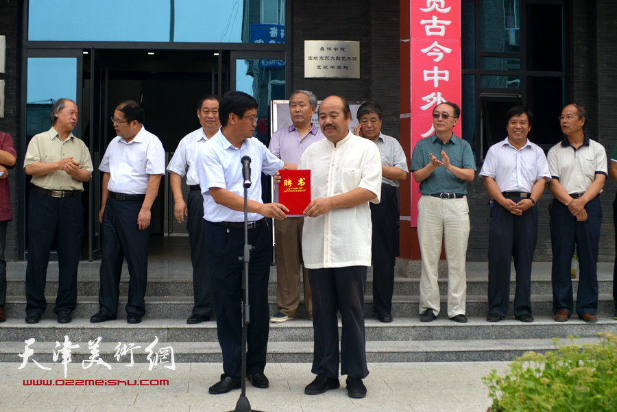 宝坻区文化广播电视局局长康德鸿向首任院长孟庆占颁发聘书。