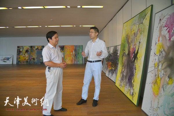 程亚杰在天津创作现场䤩津美协秘书长李耀春亲切交谈。