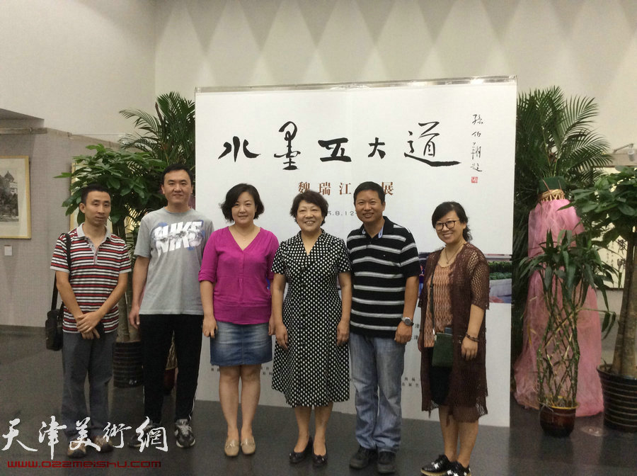 图为张俊芳与魏瑞江名师工作室核心成员在画展现场。