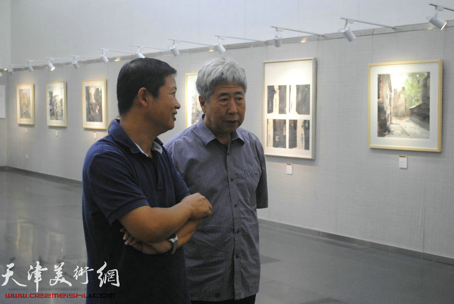 图为刘长兴、魏瑞江在画展现场交流。