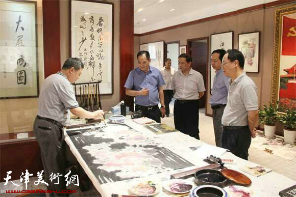江西将军书画院院长熊伟文与来宾一起欣赏王其华现场作画。