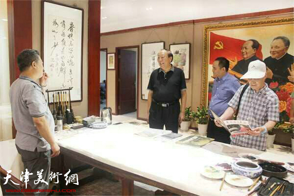 江西将军书画院院长熊伟文与来宾一起欣赏王其华现场作画。