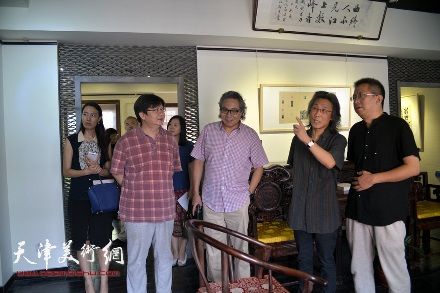 图为李毅峰、赵均、李军、王凤、吴沙在观看胡健作品。