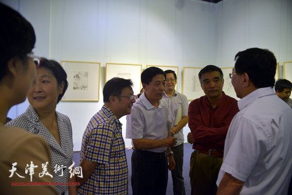 侯军在展览现场与天津日报、今晚报负责人交谈。