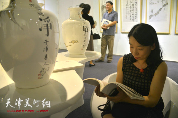 庄雪阳在展览现场阅览四人展作品集。