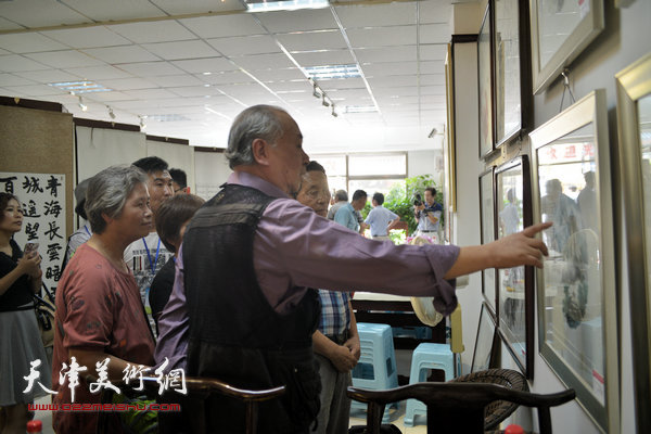王振德、张文琴在观赏首届书画展作品。